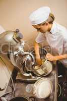 Baker using large mixer to mix dough