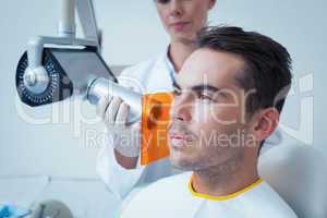 Serious young man undergoing dental checkup