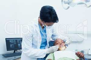 Female dentist examining boys teeth