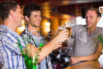 Happy friends toasting with pints of beer on patricks day