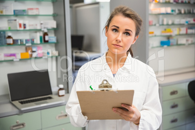 Junior pharmacist writing on clipboard