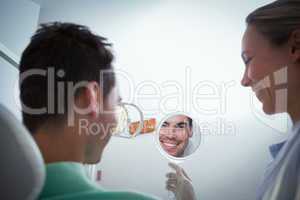 Smiling young man looking at mirror