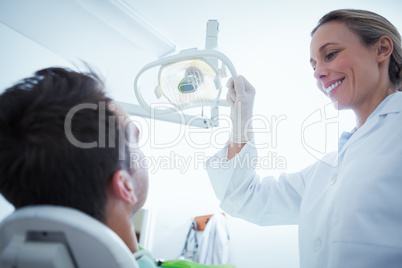 Female dentist examining mans teeth