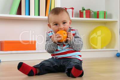 Baby beim Essen einer Orange Frucht