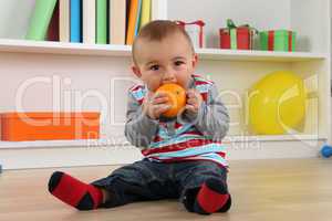 Baby beim Essen einer Orange Frucht