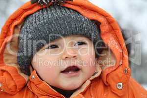 Portrait lachendes Baby im Schnee im Winter