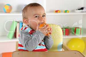 Baby Kind beim Essen einer Orange Frucht