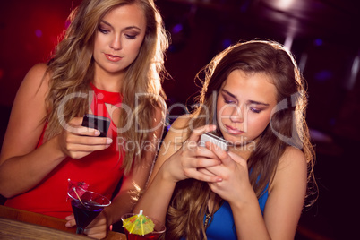Pretty friends looking at smartphones Pretty friends looking at smartphones