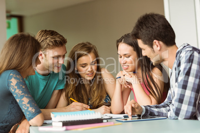 Smiling friends sitting studying together