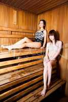 Two young women relaxing in a sauna