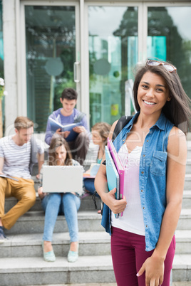 Pretty student smiling at camera outside