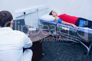 Doctor checking blood pressure of woman