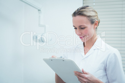 Female dentist checking reports
