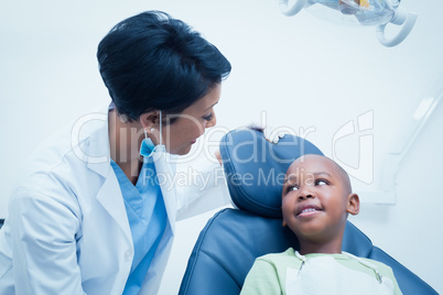 Female dentist examining boys teeth