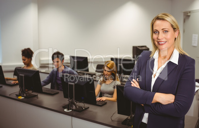 Computer teacher smiling at camera with arms crossed