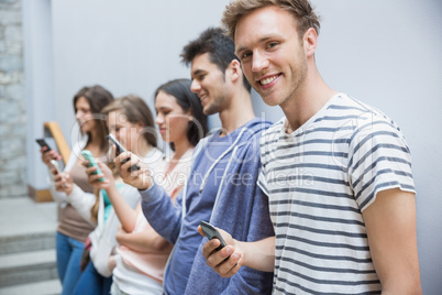 Students using their smartphones in a row