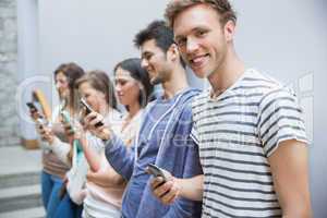 Students using their smartphones in a row