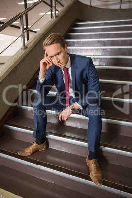 Stressed businessman sitting on steps