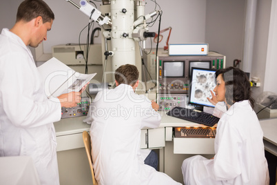 Biochemistry students using large microscope and computer