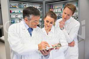 Team of pharmacists looking at clipboard