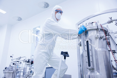 Scientist standing on ladder looking at the camera