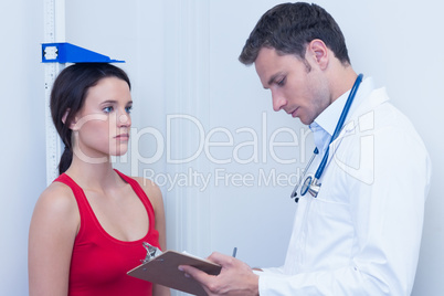 Doctor writing size of his patient on clipboard