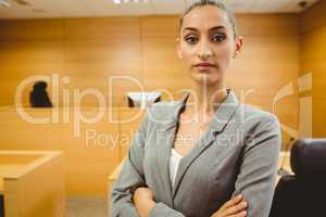 Unsmiling lawyer looking at camera crossed arms