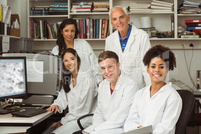 Science students smiling at camera with professor