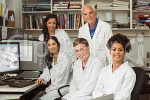 Science students smiling at camera with professor