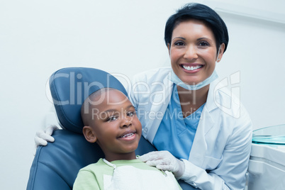 Portrait of female dentist examining boys teeth