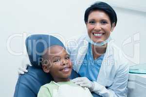 Portrait of female dentist examining boys teeth