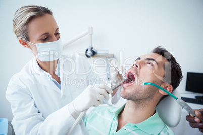 Female dentist examining mans teeth