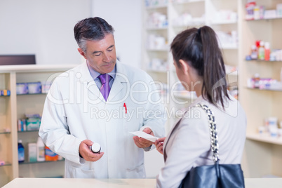 Customer handing a prescription to a pharmacist