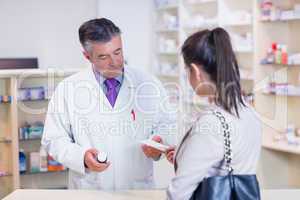 Customer handing a prescription to a pharmacist