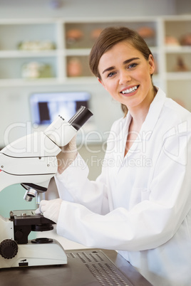 Young scientist working with microscope