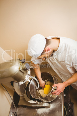 Baker using large mixer to mix dough