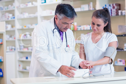 Pharmacist showing blood pressure of his patient to her