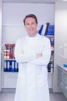 Portrait of a smiling biochemist standing with arms crossed
