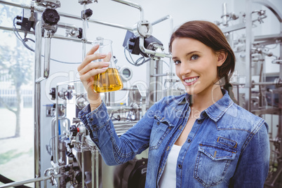 Smiling woman holding a beaker of beer Smiling woman holding a beaker of beer