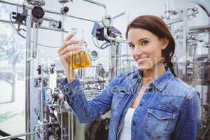 Smiling woman holding a beaker of beer