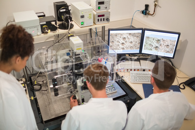 Biochemistry students using large microscope and computer