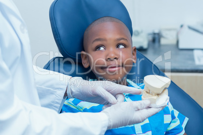 Cropped dentist showing boy prosthesis teeth