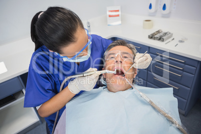 Dentist examining a patient with tools