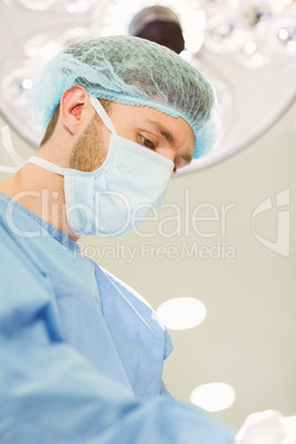 Young surgeon wearing mask and cap