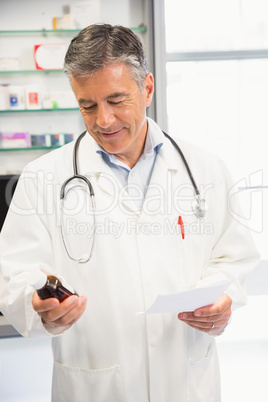 Happy pharmacist holding medicine jar