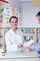 Portrait of a smiling pharmacist holding a prescription
