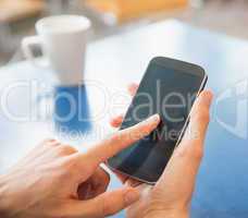 Young student using his smartphone in cafe