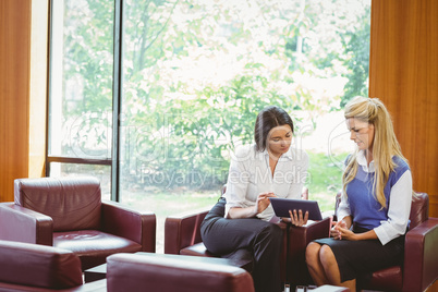 Businesswomen having a meeting and using tablet