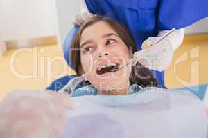 Dentist and his dental assistant examining a young patient