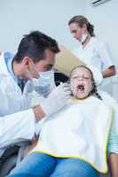 Male dentist examining girls teeth